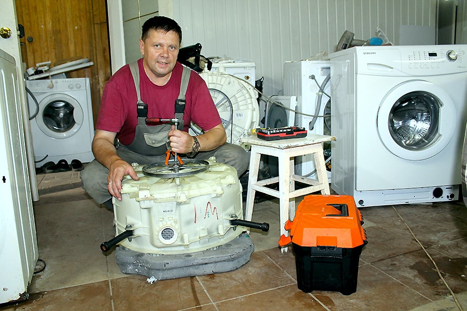Мастер разбирает и ремонтирует бак у стиральной машины в Ишимбае